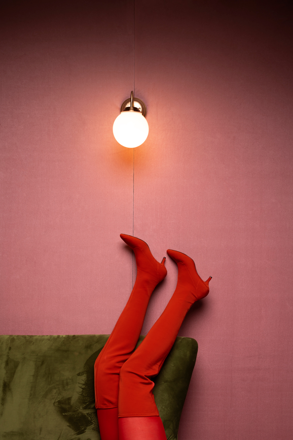 woman with red clothes in a pink room with on a green couch - brand image for Feel You Creative Brand Design